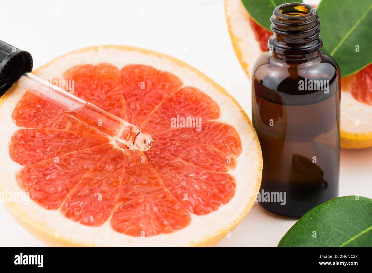 dropper with grapefruit oil on the fruit lobe. bottle with grapefruit