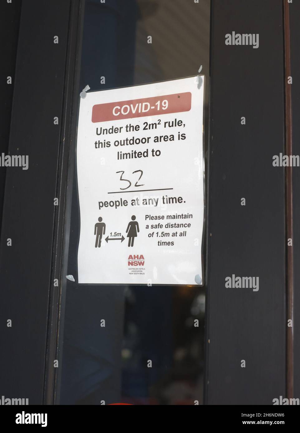 Australian Covid-19 signage on window of commercial premises indicating social distancing requirement and limits on number of people allowed Stock Photo