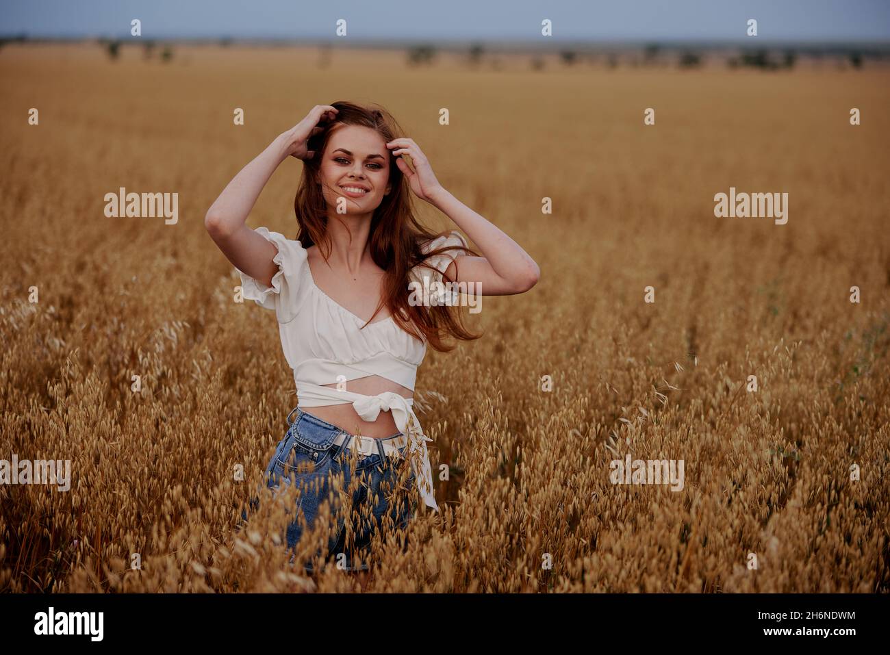 smiling woman standing in a field in nature wheat agriculture landscape ...