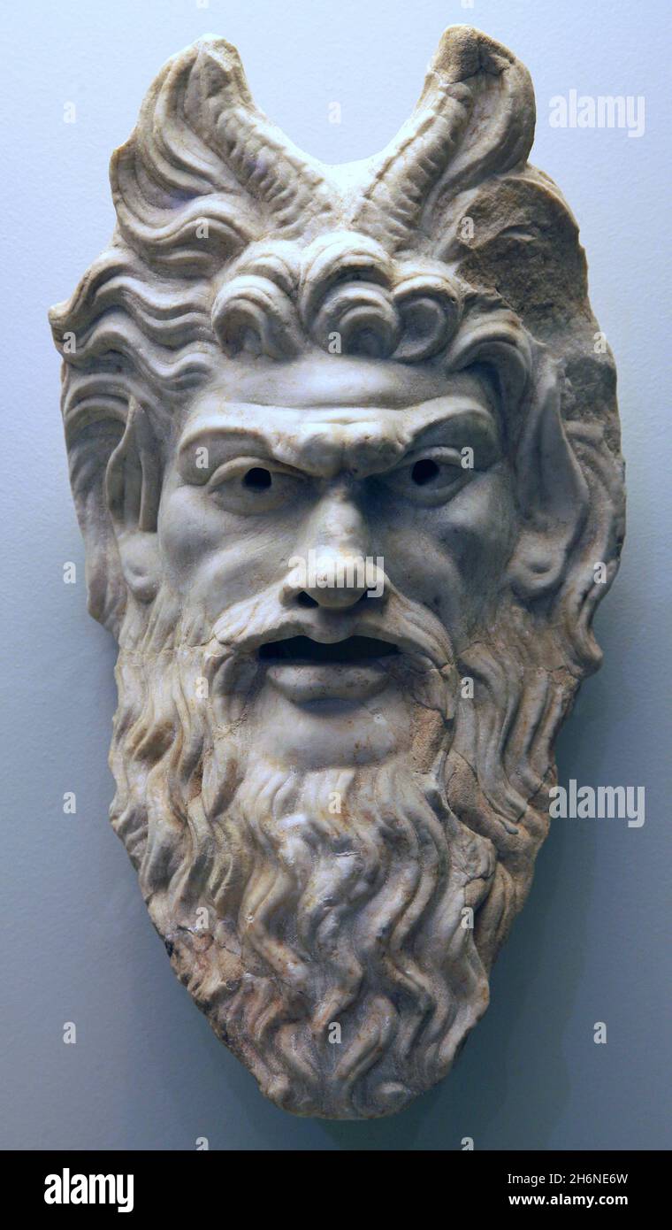 Theatre mask representing the God Pan,the god of the wild, shepherds and flocks,nature of mountain wilds, rustic music and impromptus,and companion of the nymphs.He has the hindquarters,legs,and horns of a goat.Roman;first century.Marble. Stock Photo