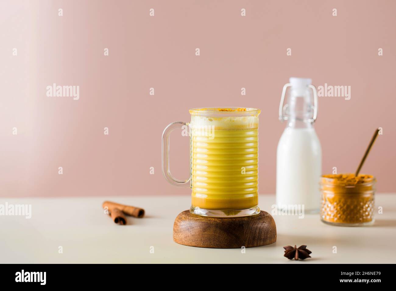 Latte turmeric on a pink background. Moon milk for better sleep