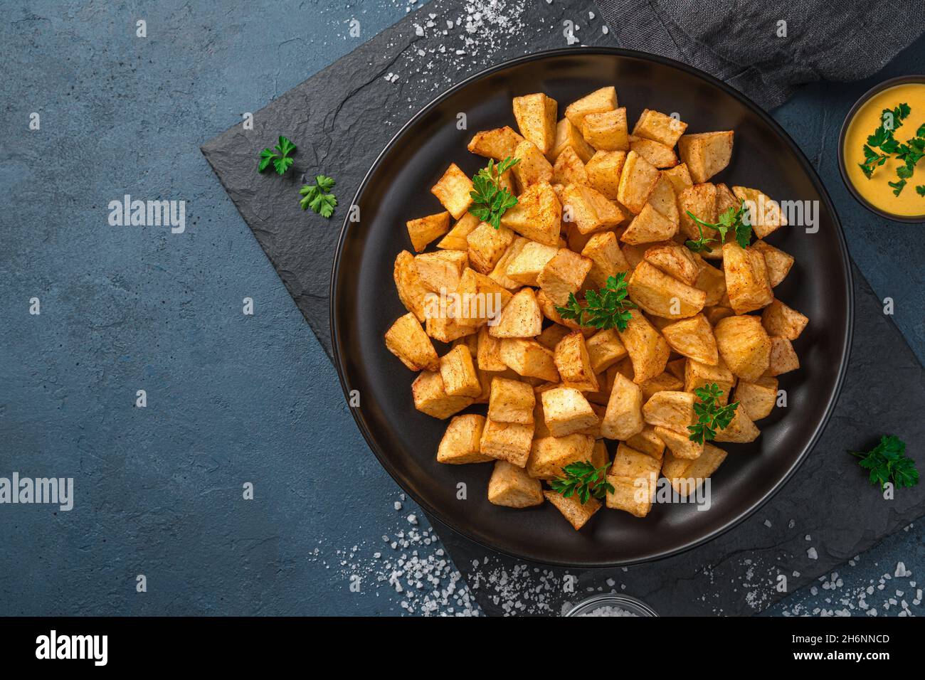 Patatas bravas with sauce on a graphite background with space to copy