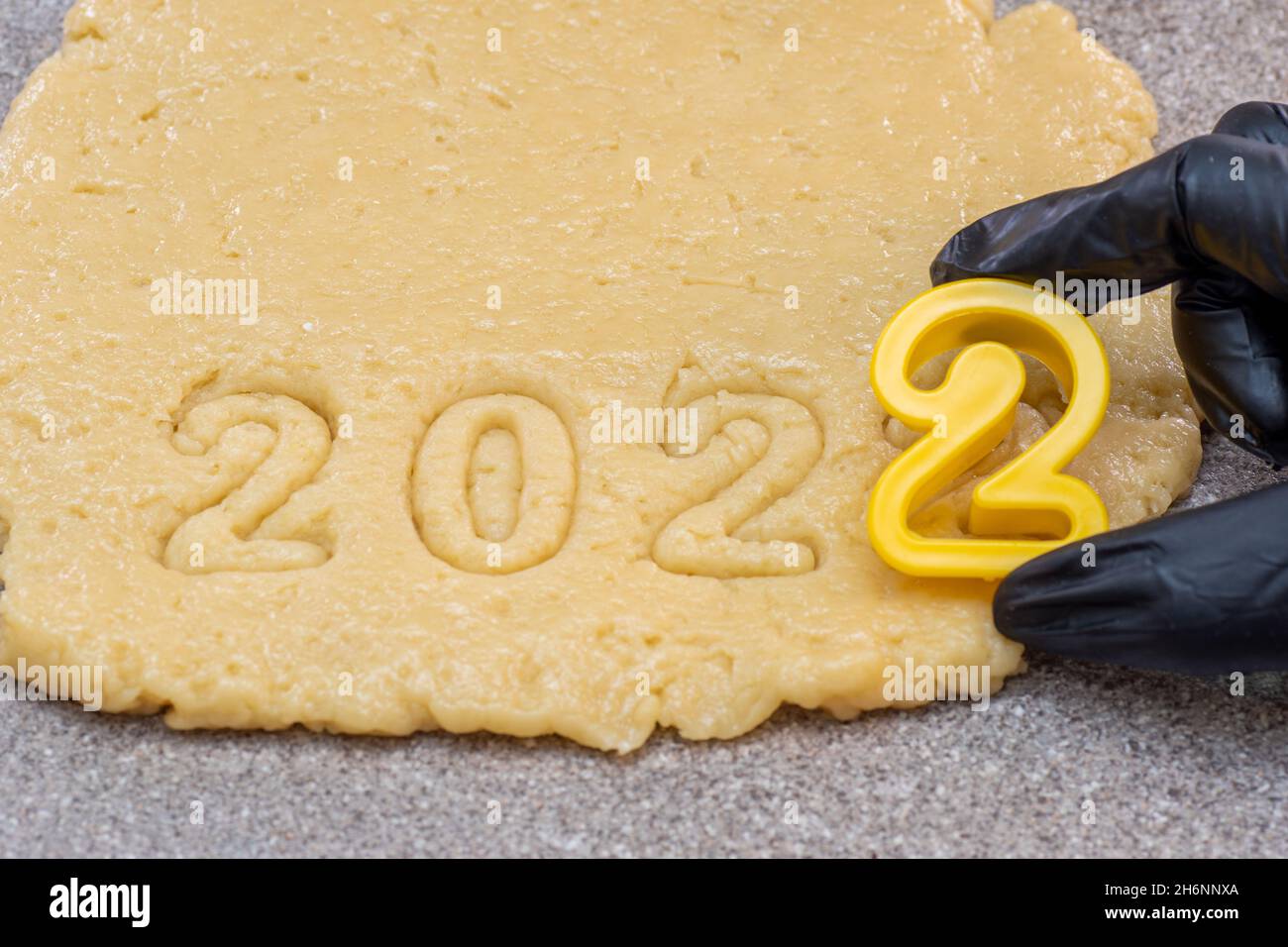 La Nueva Bakery Christmas 2022 New Year 2022 Bakery Concept. A Hand In A Black Glove Cutting Out The Date  2022 From Raw Dough For New Year's And Christmas Cookies, Top View. Happy N  Stock Photo - Alamy