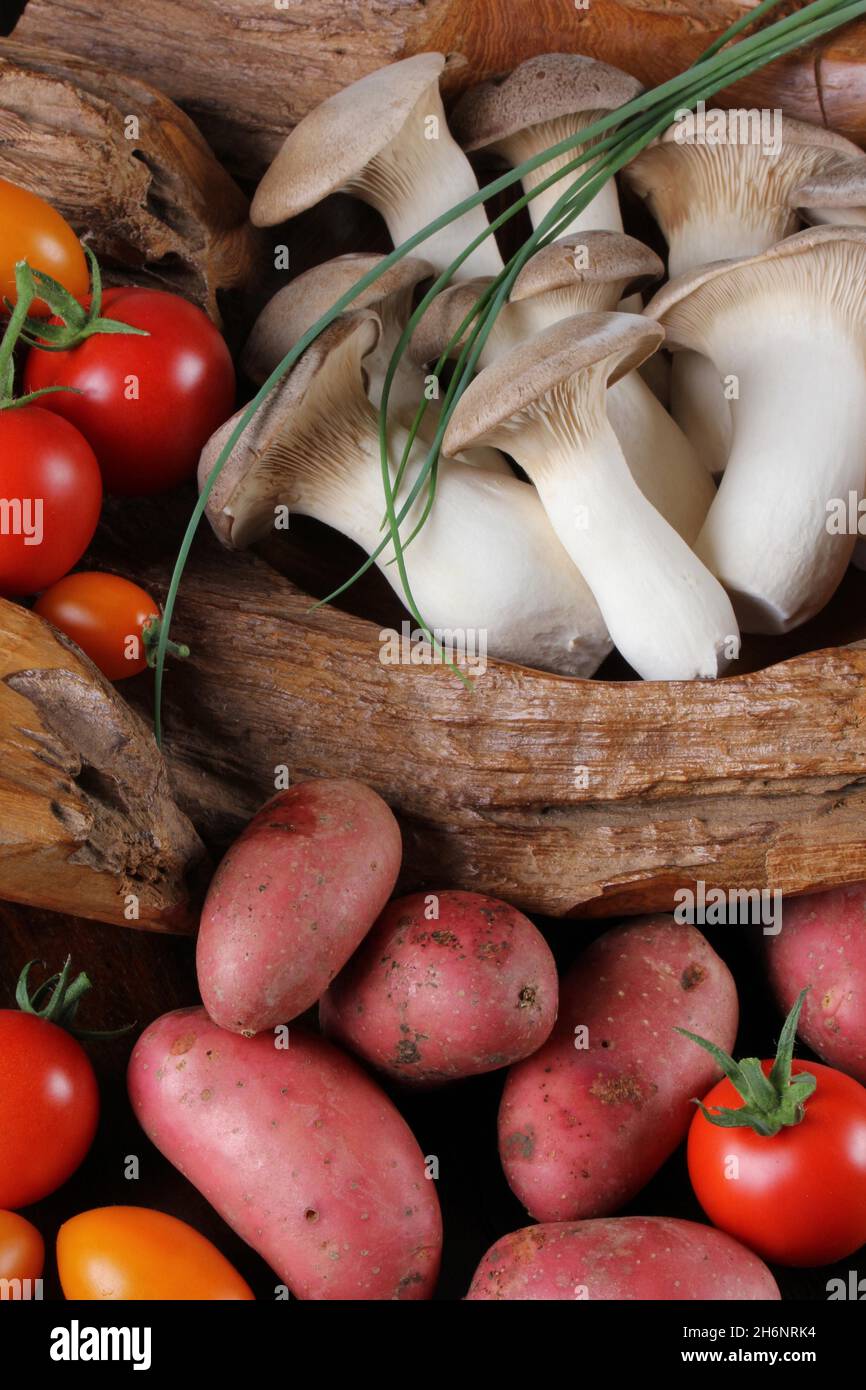 King trumpet mushrooms (Pleurotus eryngii), tomatoes (Solanum lycopersicum) and red potatoes (Solanum tuberosum) Stock Photo