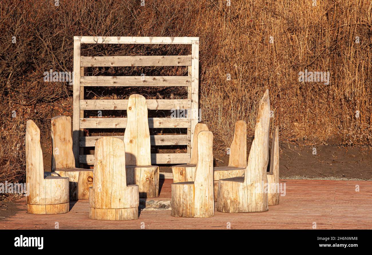wooden chairs around bonfire for tourists, Kamchatka Peninsula Stock Photo