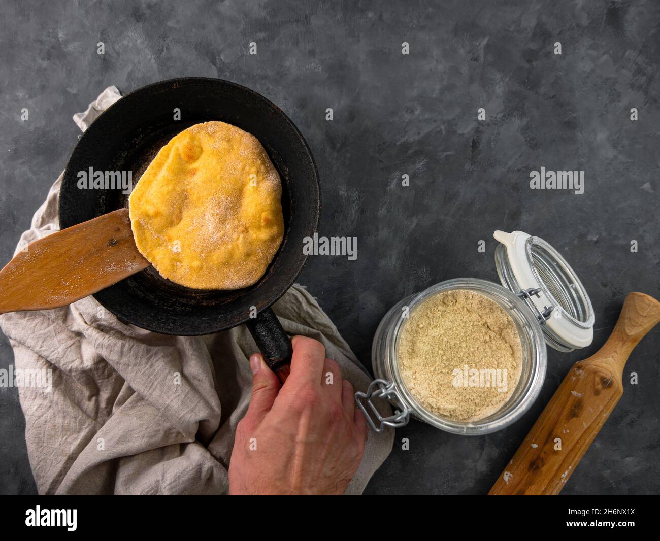Homemade corn flatbread meal frying pan in male hand. Handmade mexican