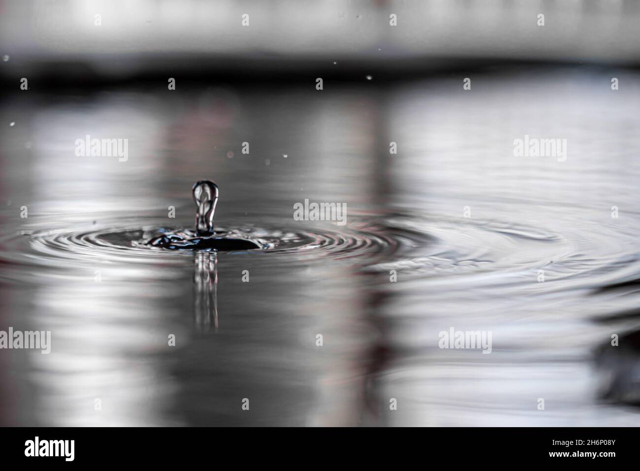 Closeup of the water droplet falling into the water Stock Photo - Alamy