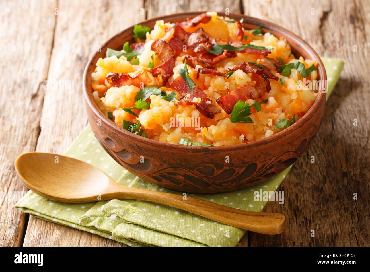 Hutspot Dutch, hochepot French or hotchpotch English, is a dish of boiled  and mashed potatoes, carrots and onions close up in the bowl on the table.  V Stock Photo - Alamy