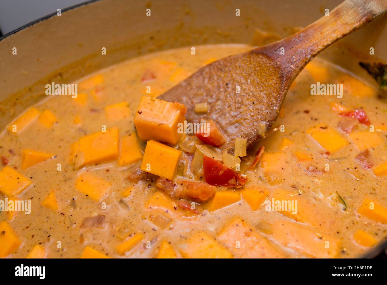 Chopped pumpkin, onions, tomatoes and mustard seeds cooking in coconut