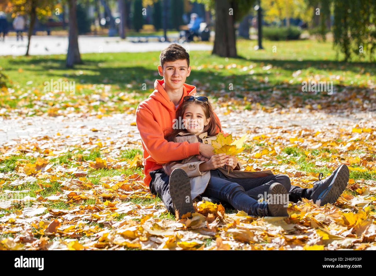 Happy teenager brother and sister in the autumn park Stock Photo - Alamy