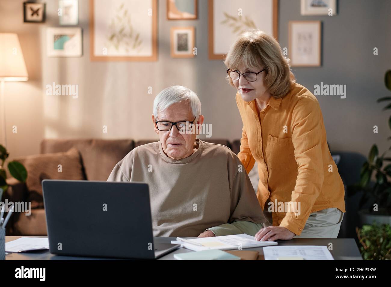 Senior couple using laptop together at the table, they learning to use online service at home Stock Photo