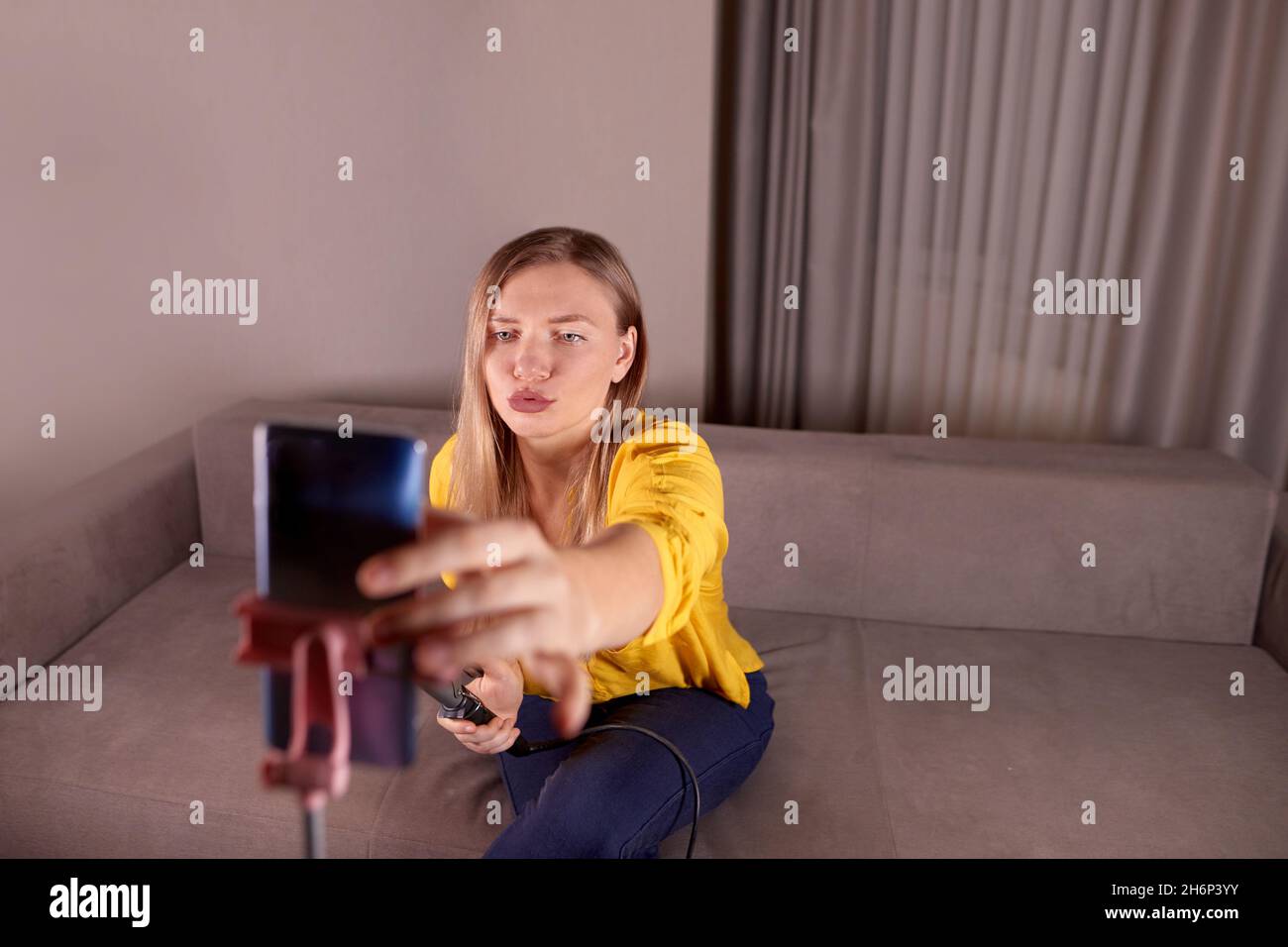 young woman sets up a live broadcast on the phone to go out on social network and talk about beauty work Stock Photo