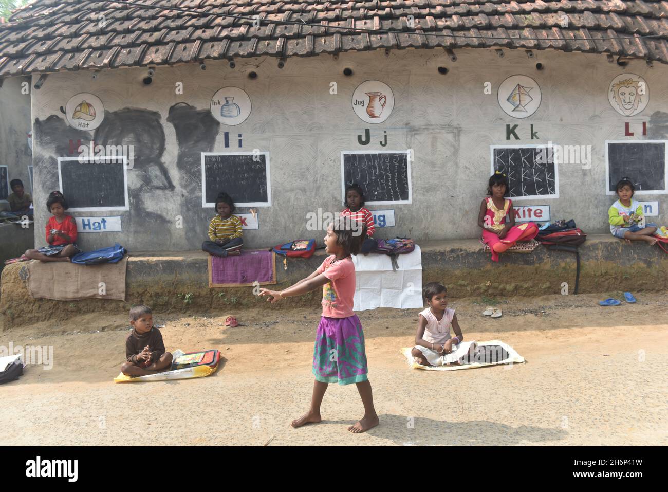 Deep Narayan Nayak, a school teacher in a small tribal village of West Bengal who has turned mud walls into blackboards and converted the street into open air classrooms and taught children. All educational schools were shut down after strict COVID-19 restrictions imposed across the country from March last year. According to the locals after the pandemic restriction imposed, the children of the village used to loiter and were detached with their entire educational system. Deep Narayan Nayak teaches the children everything from their schools syllabus and also made them aware of the recent situa Stock Photo