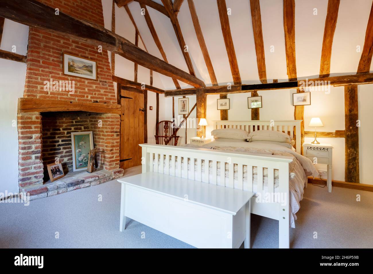 Stoke By Clare, England October 17 2019: Bedroom interior inside traditional english cottage with exposed brickwork and beams, inglenook fireplace and Stock Photo