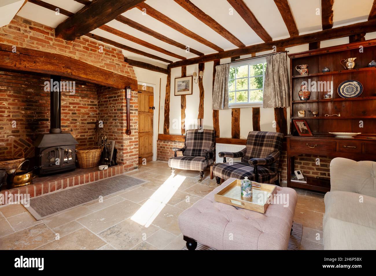 Stoke By Clare, England October 17 2019: Living room interior inside traditional english cottage with exposed brickwork and beams, inglenook fireplace Stock Photo