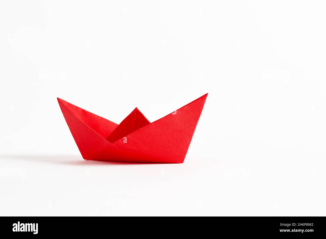 Origami red paper boat on white background. Stock Photo