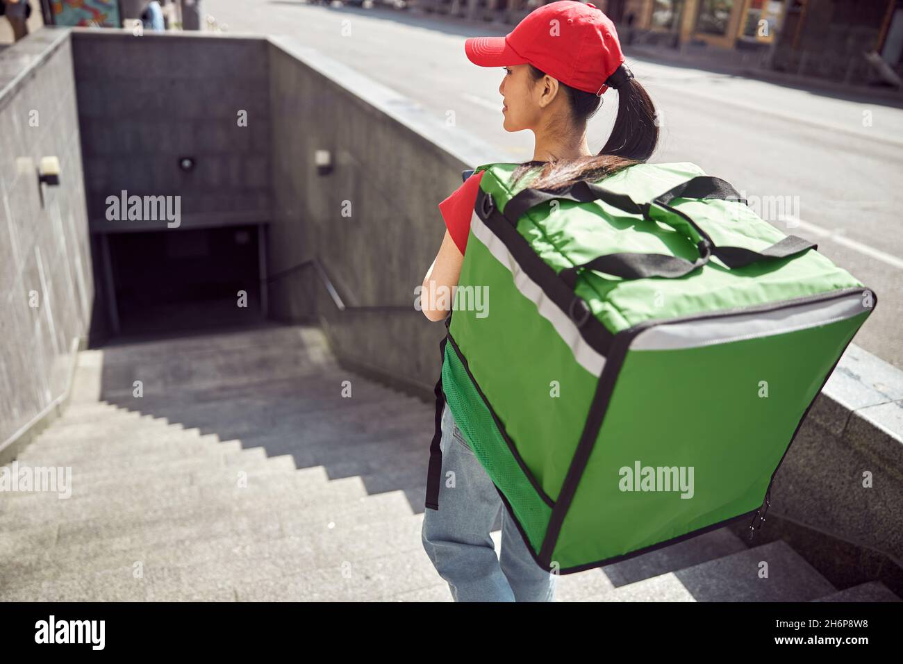 Asian worker of food delivery service walking down street Stock Photo ...