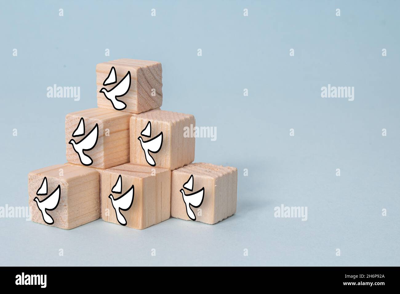 Wooden cubes the white pigeon icons on a gray background - the concept of peace Stock Photo