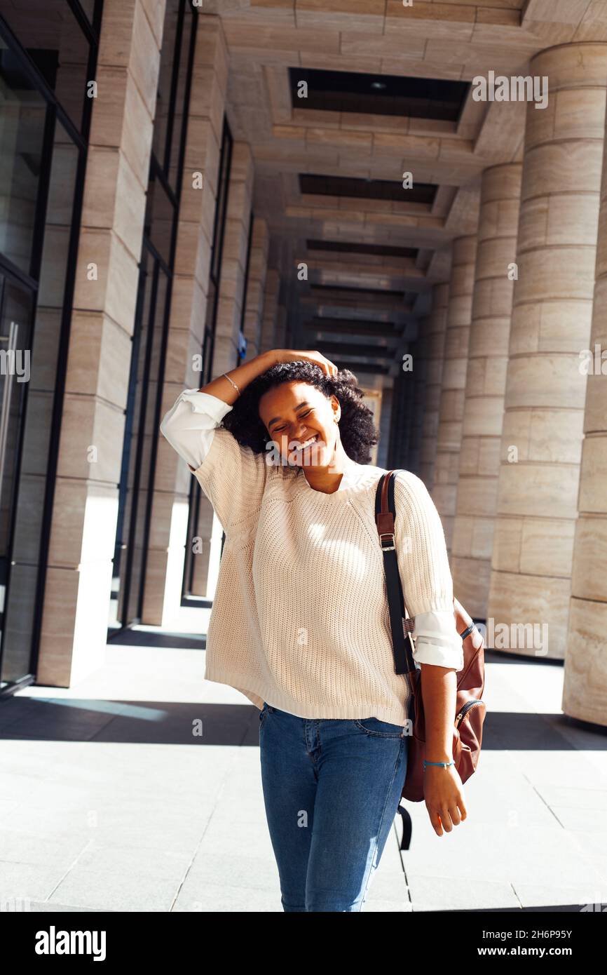 young pretty african girl posing cheerful on city background, lifestyle outdoor people concept Stock Photo