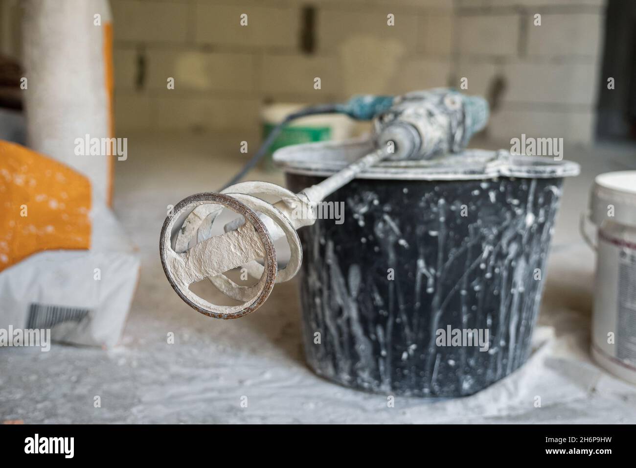 On the black bucket lies a hole punch with a dry mixer nozzle. In the