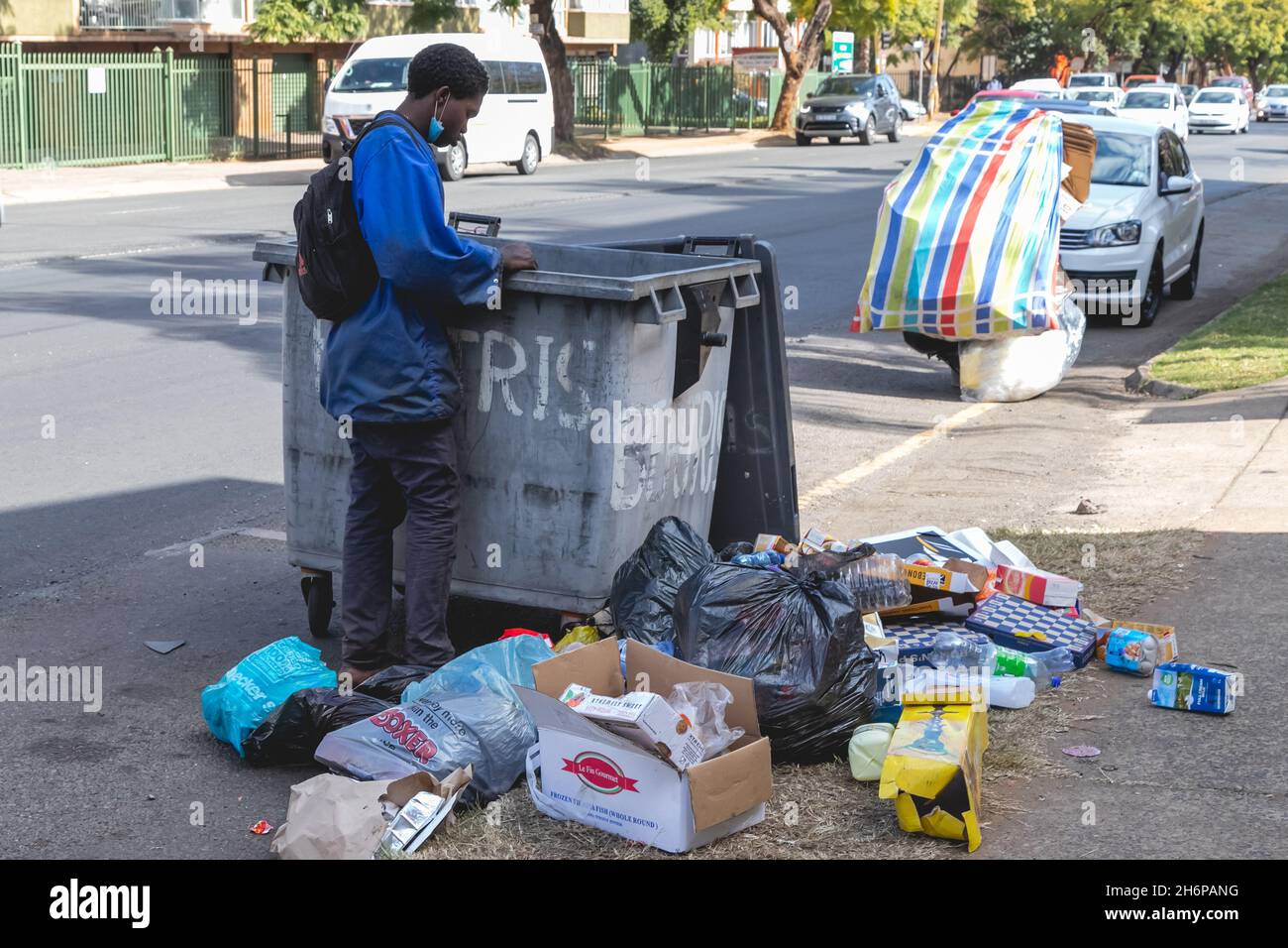Johannesburg, South Africa - 22nd June, 2021: Refuse picker looking through refuse for recyclables. Stock Photo