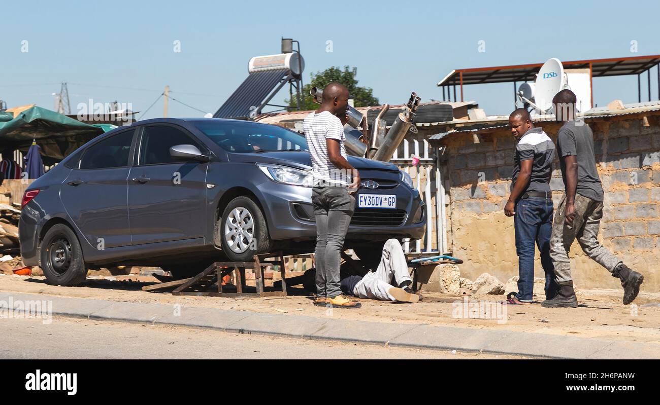 Johannesburg, South Africa - 13th May, 2021: Car being repaired at a roadside mechanic. Mechanic under car. Stock Photo