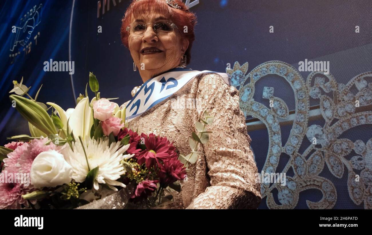 Holocaust survivor Selina Steinfeld, 86, who was born in Romania poses for a photo after being crowned 'Miss Holocaust Survivor' in the annual Holocaust Survivor Beauty Pageant at the Friends of Zion Museum on November 16, 2021 in Jerusalem, Israel. Hundreds of Holocaust survivors applied to be in the competition, which was organized by the Christian evangelist museum Friends of Zion and Yad Ezer L’Haver, an organization dedicated to assisting needy Holocaust survivors in Israel. Stock Photo