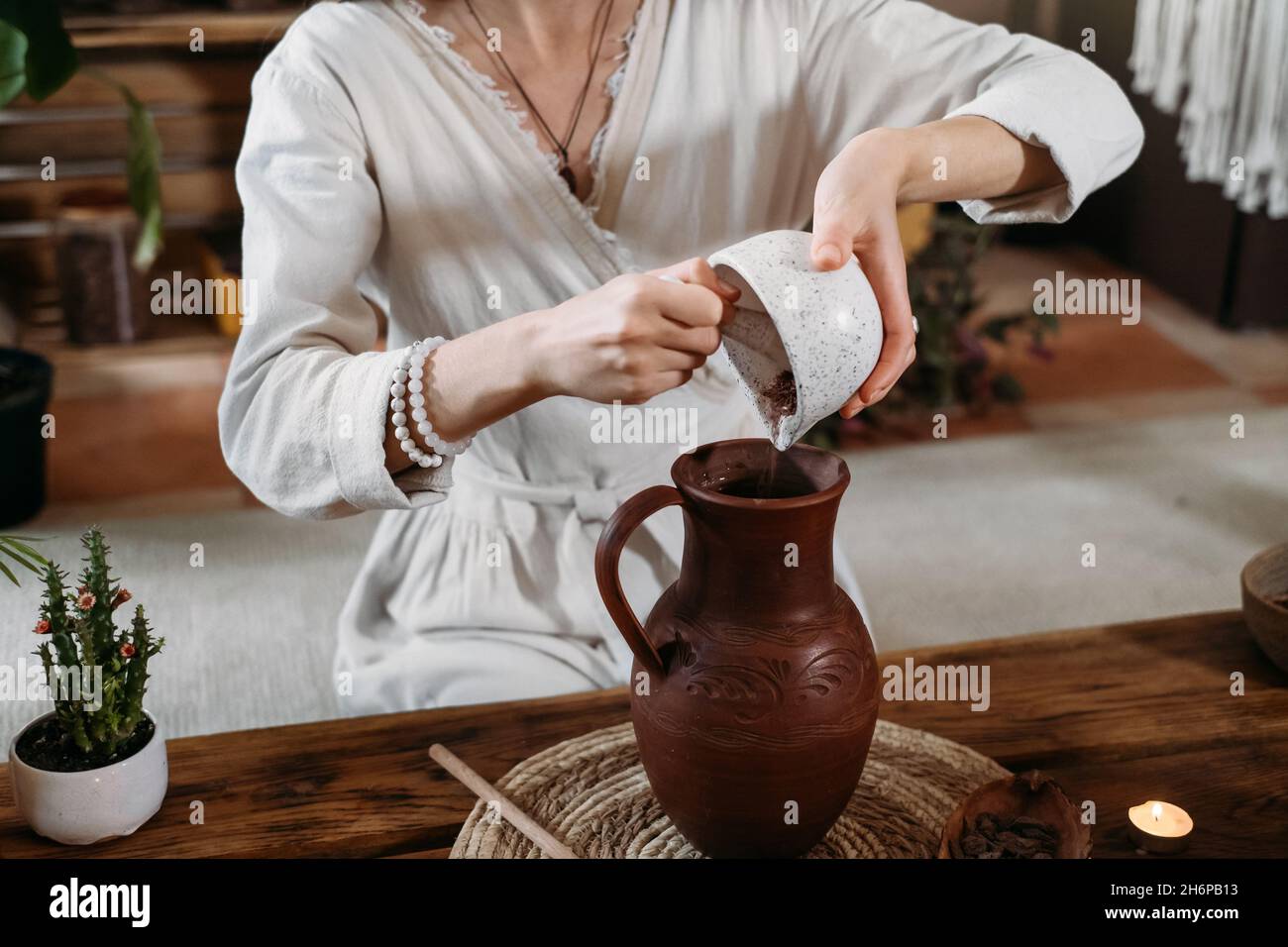 Cocoa Personal Ritual Cacao ceremony in atmospheric space with green plants and candles ...