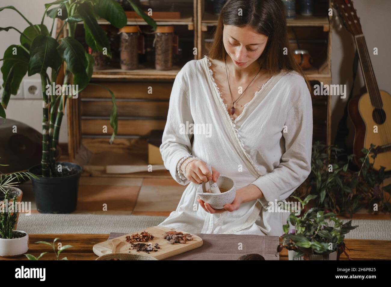 Cocoa Personal Ritual Cacao ceremony in atmospheric space with green plants and candles ...