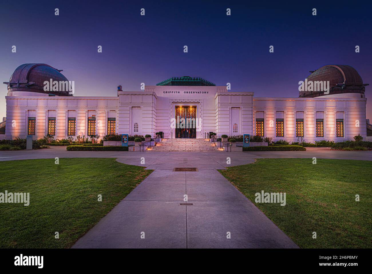 Los Angeles, CA—Nov 14, 2021; view of front of Griffith Observatory illuminated at sunrise showing copper domes and door of the California landmark in Stock Photo