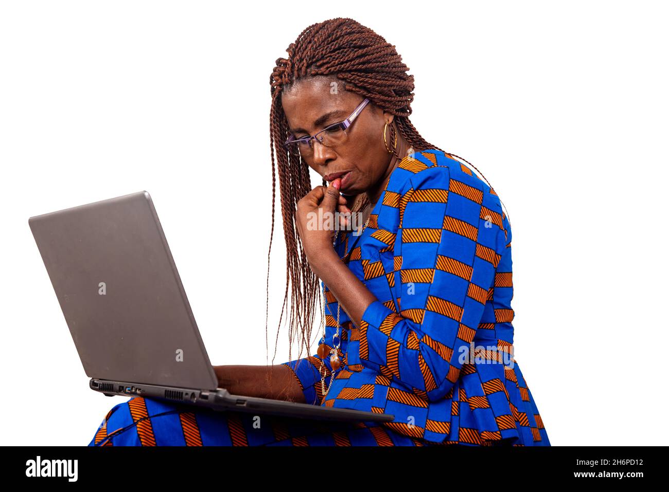 Adult businesswoman thinking using a laptop with finger on mouth Stock Photo