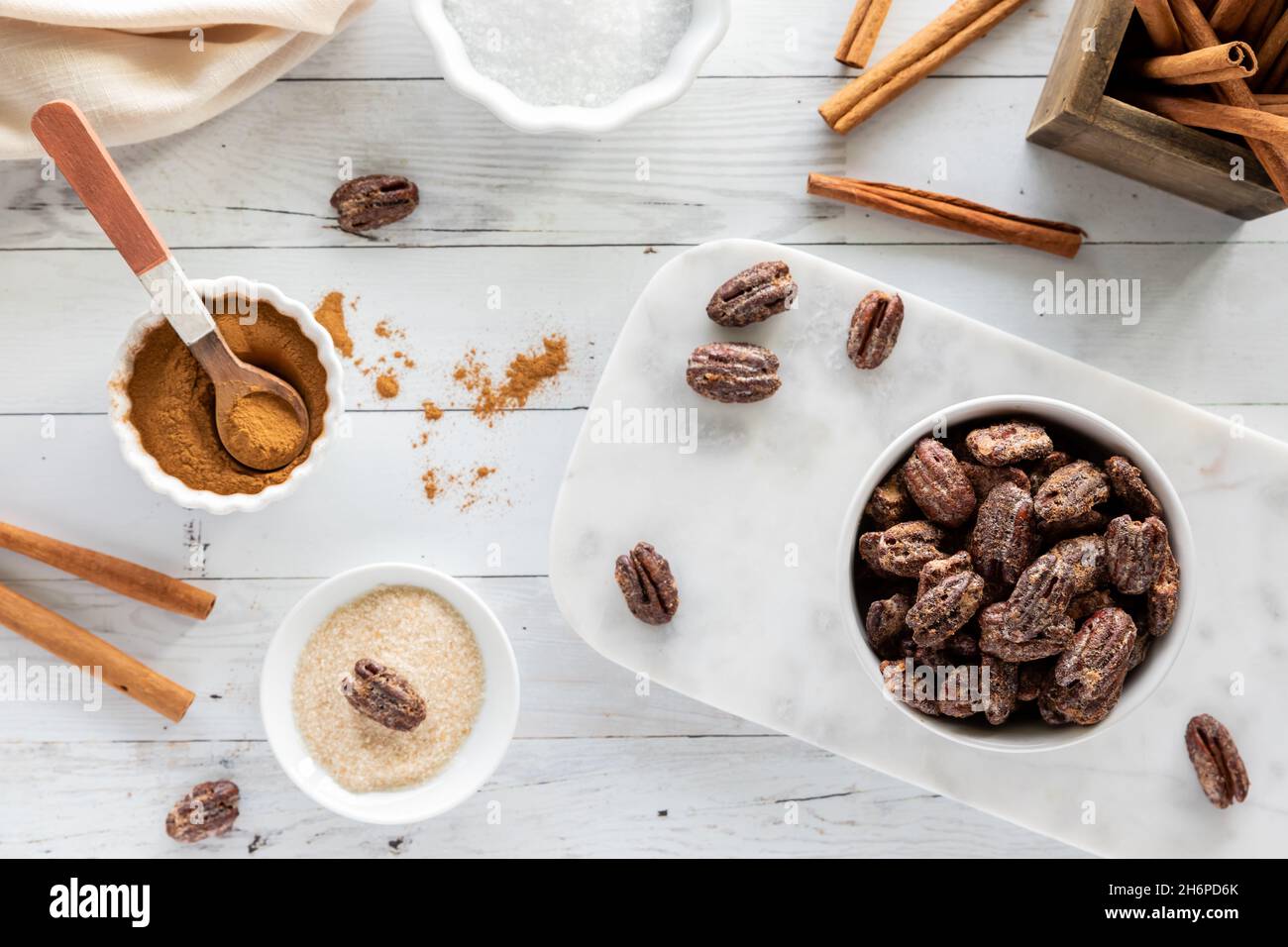 Table top view of a bowl of candied pecans with ingredients used to make them. Stock Photo