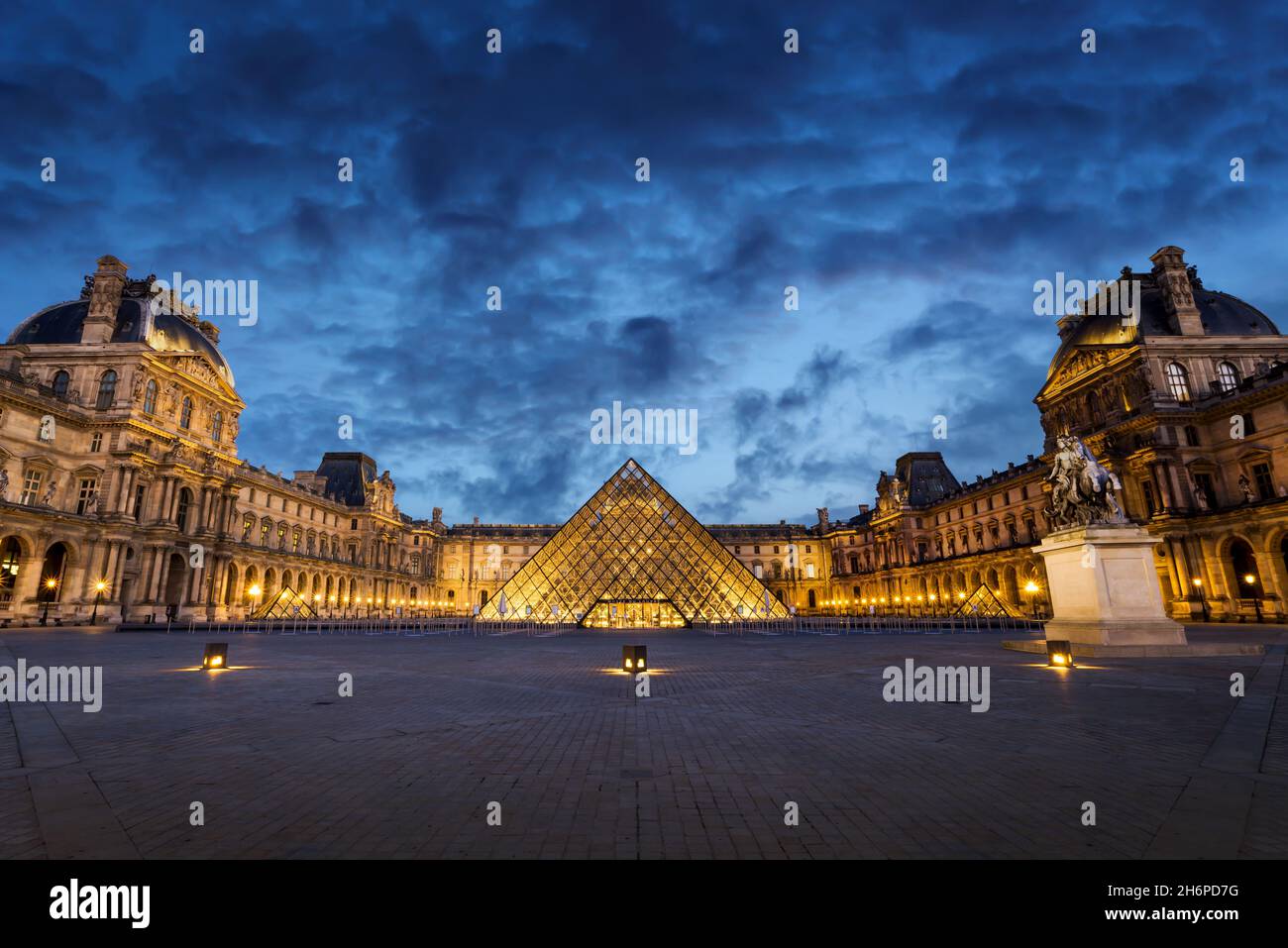 Louvre museum and the pyramid illuminated at night in Paris France Stock Photo