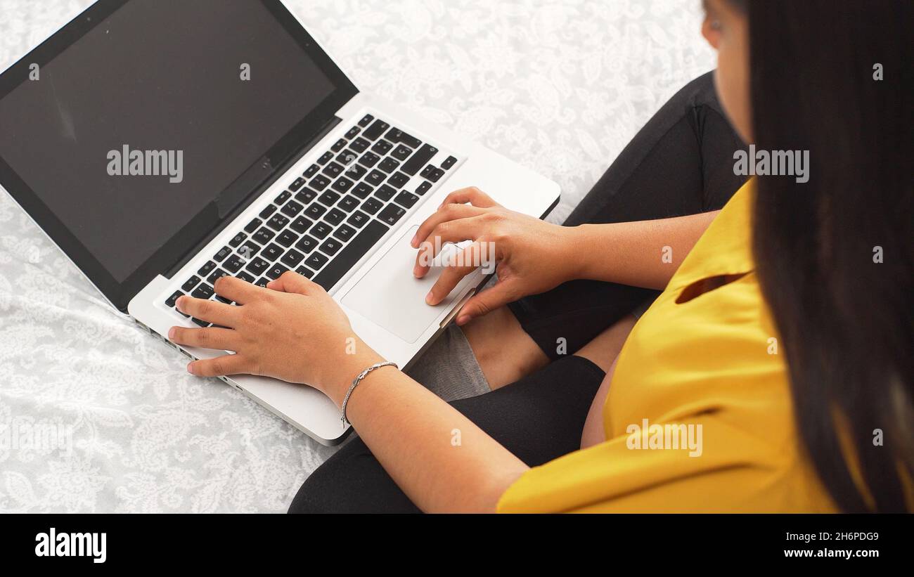 Closeup of a young woman working on a laptop. Stock Photo
