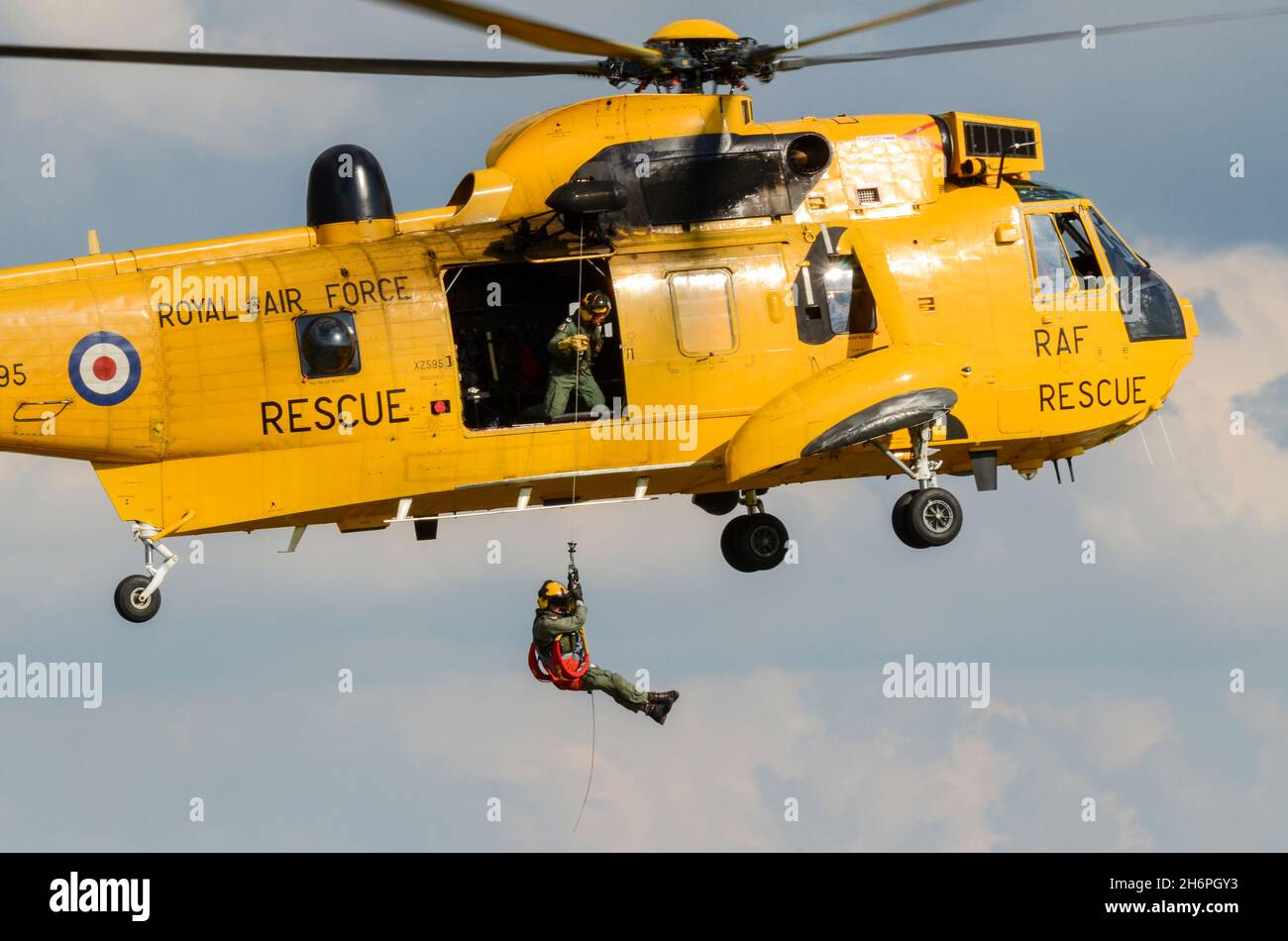 Westland Sea King mark HAR.3, Royal Air Force RAF Search and Rescue helicopter carrying out a rescue demonstration lowering a crewman down on cable Stock Photo
