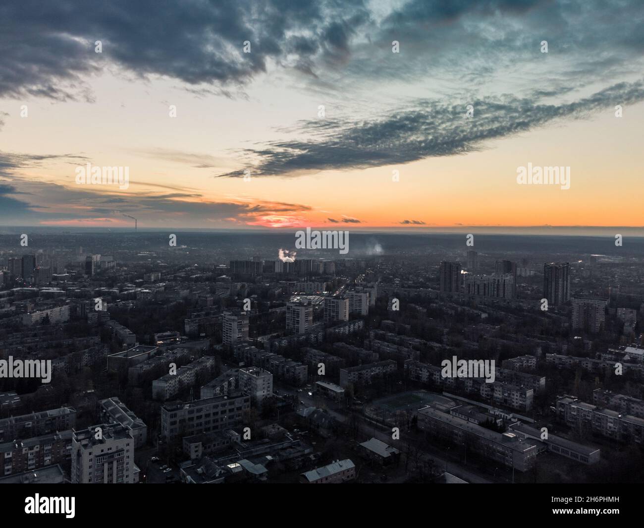 Aerial sunset evening view on residential Kharkiv city Pavlove Pole district. Gray multistory buildings with scenic bright orange cloudy sky on horizo Stock Photo