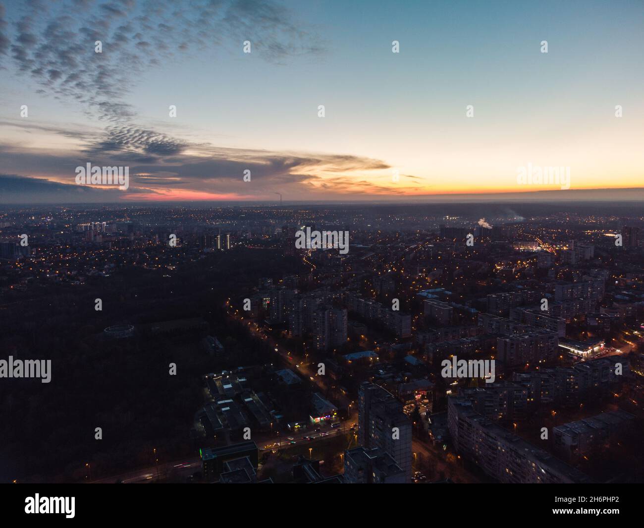Aerial view Kharkiv city center, Pavlove pole with night lights on streets of residential district, scenic sunset view with epic skyscape Stock Photo
