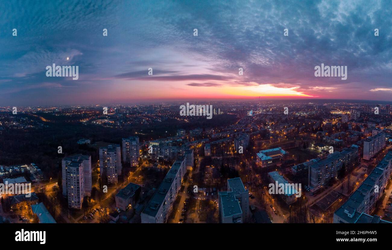 Aerial sunset scenic panorama on Kharkiv city, Pavlove pole. Night lights on streets of residential district and scenic cloudy colorful sky after suns Stock Photo