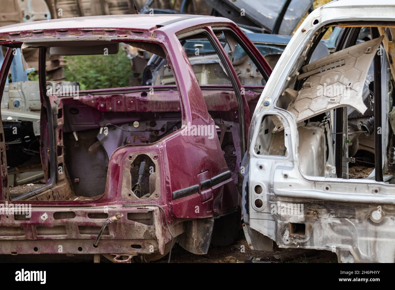 Two disassembled cars body parts outdoor close-up view. Car dump, wreck at a junkyard ready for recycling Stock Photo