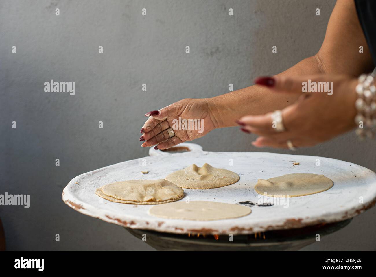 https://c8.alamy.com/comp/2H6PJ2B/woman-making-mexican-corn-tortillas-on-a-comal-2H6PJ2B.jpg