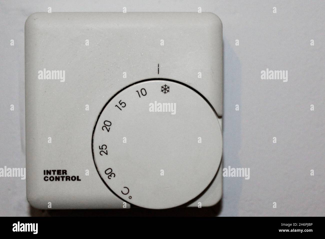 Weißer Thermostat zur Wärmeregulierung von 0 bis 30 Grad einstellbar, in einer Wohnung an einer Wand, komplett abgestellt. Stock Photo
