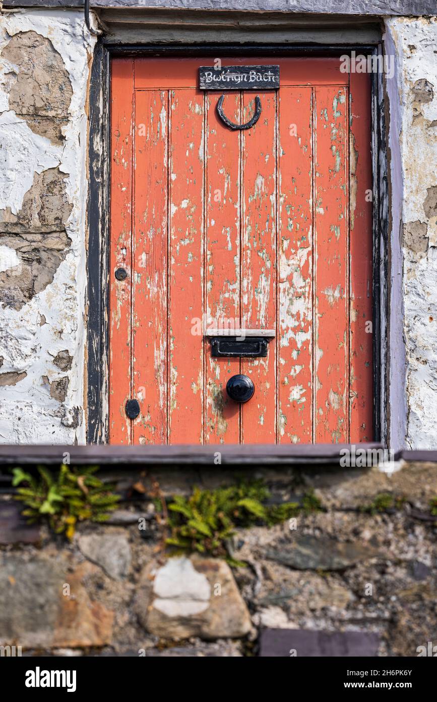 Peeling red paint on a cottage front door near Llanberis, Snowdonia, Wales, UK, Stock Photo