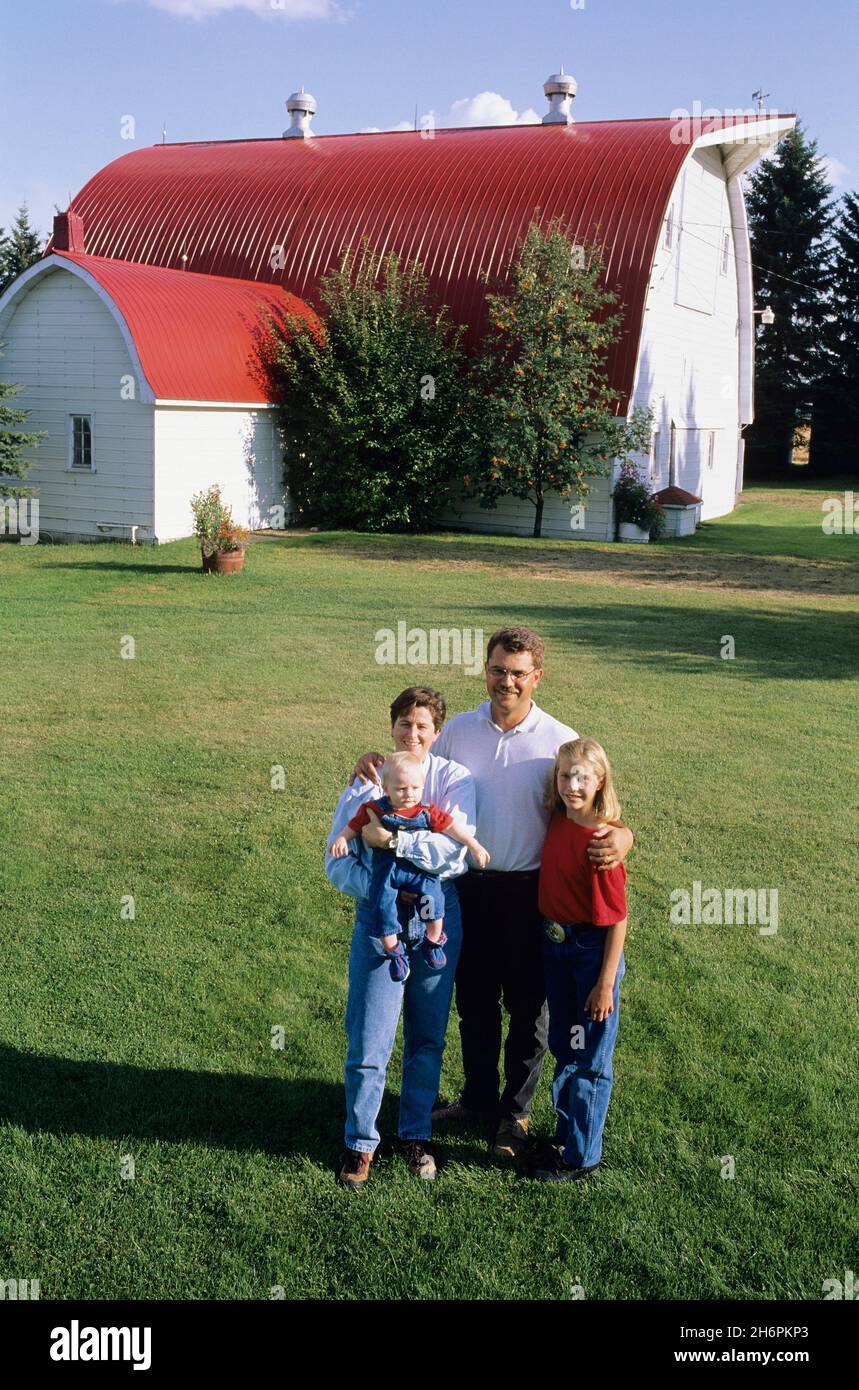 Farm Family standing in front of a Red Barn Stock Photo - Alamy