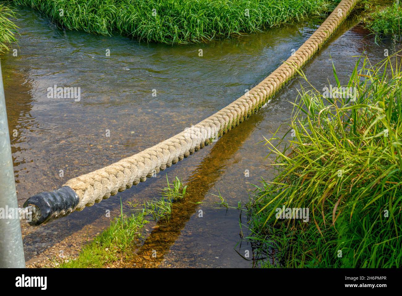 Long and thick rope lying over a river Stock Photo - Alamy
