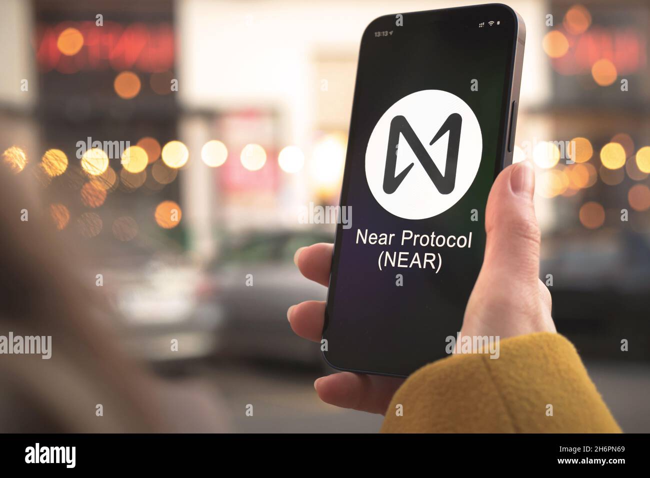 Near Protocol cryptocurrency symbol, logo. Business and financial concept.  Hand with smartphone, screen with crypto icon closeup Stock Photo - Alamy