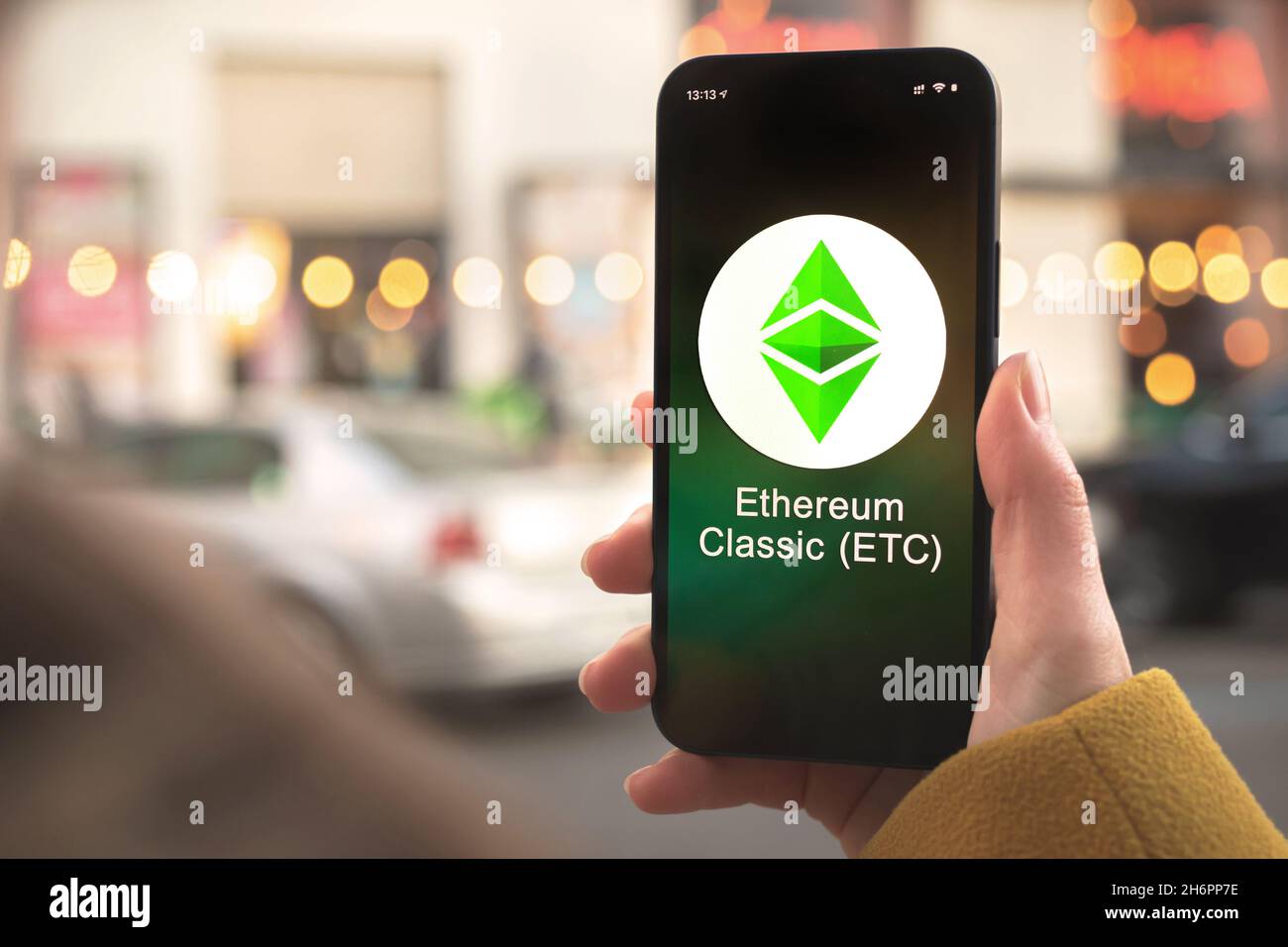 Ethereum Classic ETC cryptocurrency symbol, logo. Business and financial concept. Hand with smartphone, screen with crypto icon closeup Stock Photo