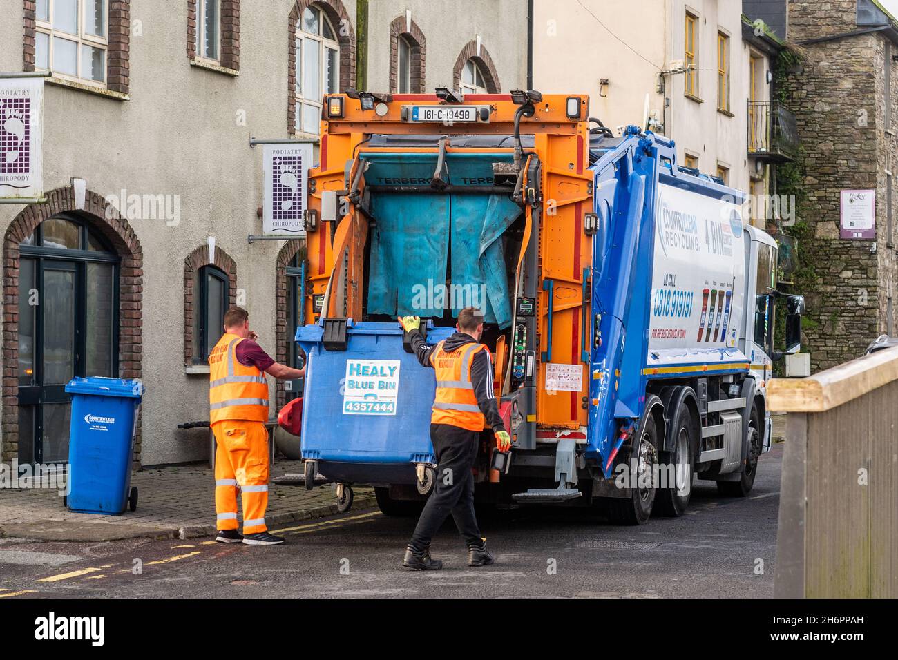 Bin men empty refuse into a bin lorry in Bandon, West Cork, Ireland. Stock Photo