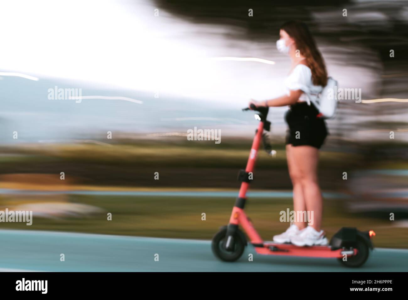 A young woman is riding a scooter. Motion blur image. Stock Photo