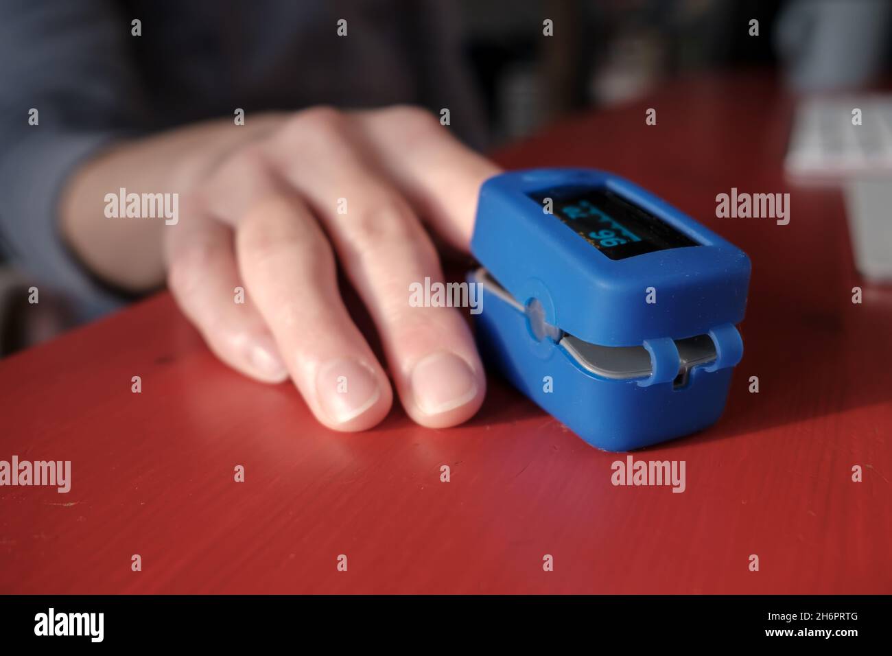 Woman uses a pulse oximeter to measure pulse rate and blood oxygen