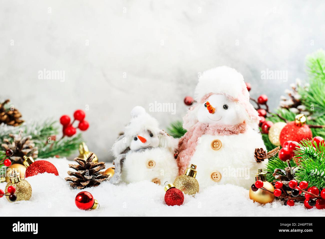 Christmas snow composition with two cute snowmen in hats and scarves in ...